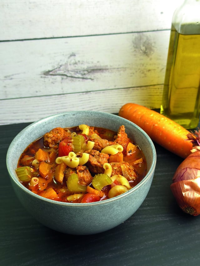 Bol de soupe aux saucisses, légumes et pâtes